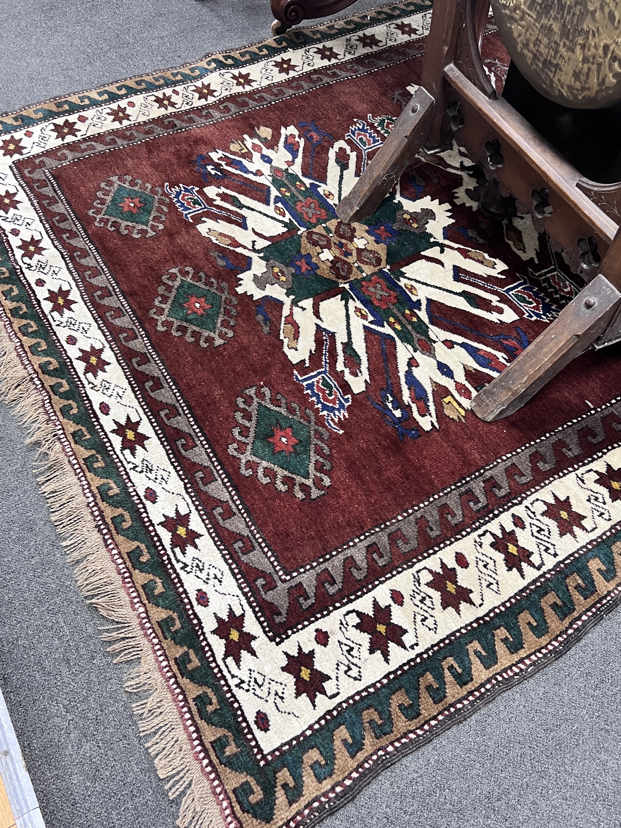 A Caucasian design burgundy ground rug 220cm x 148cm